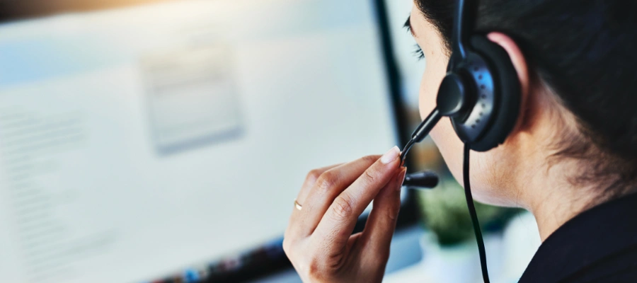 Women talking on headset in front of computer screen