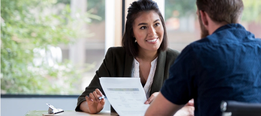 businesswoman showing paperwork to male client